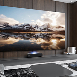 A large, wall-mounted TV displays a stunning snowy mountain landscape reflected in a lake. The sleek, modern living room has a minimalist style.