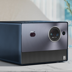 A sleek, modern projector with a metallic finish is placed on a table. Its lens and controls are visible, suggesting a high-tech, sophisticated design.