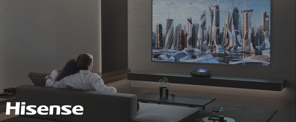 A couple watches a futuristic cityscape on a large wall-mounted TV in a dark, modern living room. "Hisense" is written in white in the corner.