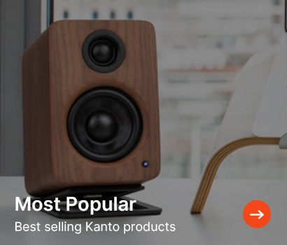 Wooden speaker with black accents on a stand, near a white chair, in a bright room. Overlay text reads "Most Popular: Best selling Kanto products."