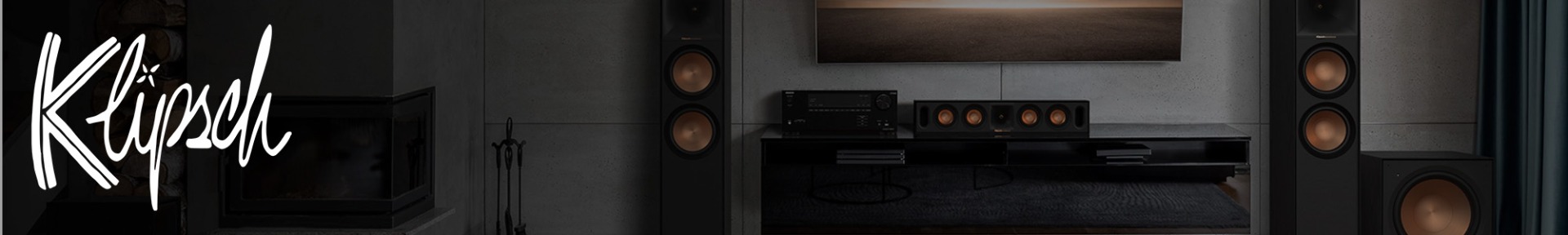 Living room with modern Klipsch audio system. Large speakers with copper cones flank a TV, creating a sleek and sophisticated atmosphere.