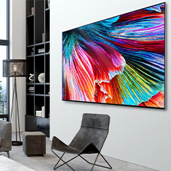 Modern living room with a large, vibrant abstract painting in blue, red, and yellow hues on the wall. Minimalist furniture includes a sleek chair and lamp.