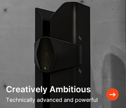 Sleek black speaker against a gray concrete wall, with text "Creatively Ambitious" and "Technically advanced and powerful" alongside an orange arrow.