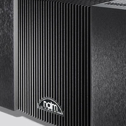 Close-up of a sleek black audio amplifier with a textured, ridged exterior. A small logo at the bottom centre reads "naim" on a smooth panel.