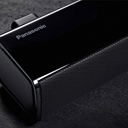 Sleek black Panasonic soundbar on a dark surface, showcasing modern design with a metallic speaker grille, conveying a sense of elegance and high quality.