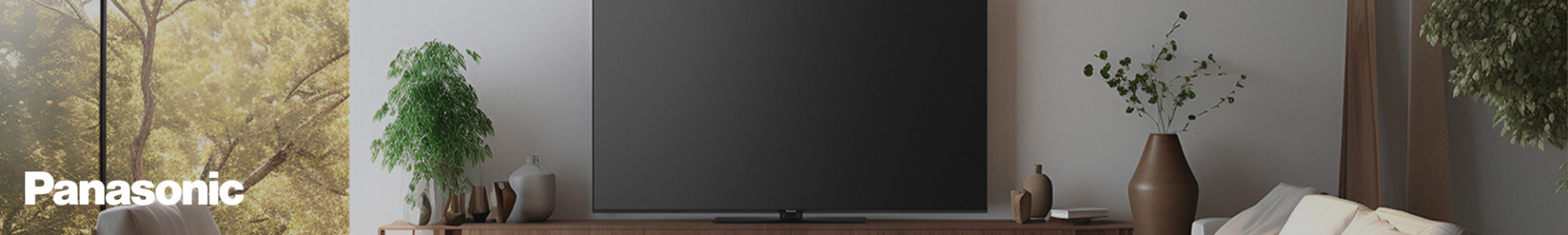 A sleek Panasonic TV on a wooden stand in a modern living room with plants, soft cushions, and natural light, creating a calm and inviting atmosphere.