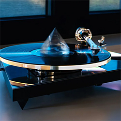 A sleek, modern turntable with a reflective black surface and silver accents plays a vinyl record. A cone-shaped cover adds a futuristic touch.