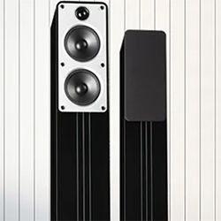 Two sleek, black tower speakers against a white, striped background. One speaker shows dual woofers and a tweeter; the other is side-view, emphasizing modern design.