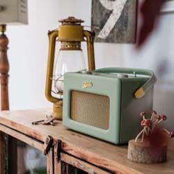 Vintage setup with a green retro radio and yellow lantern on a wooden cabinet. Warm tones create a nostalgic, cosy atmosphere.