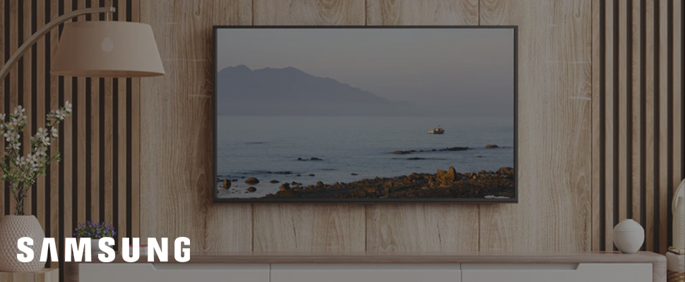 A modern living room features a large, flat-screen TV displaying a calm seascape. Sleek wooden panels and a floor lamp add a minimalist, cosy feel.