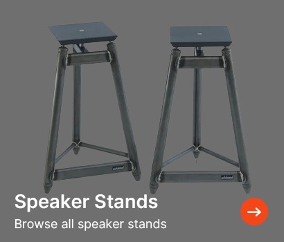 Two sleek, metallic speaker stands on a grey background. The text reads "Speaker Stands" with a prompt to "Browse all speaker stands" highlighted by an orange arrow.
