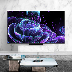 TV on a marble wall displays a vibrant, abstract floral design in neon blues and purples. Below is a modern coffee table with books and decor.