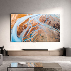 A large, vivid abstract painting depicting a river and canyon landscape hangs in a modern, minimalist living room with neutral tones and sleek furniture.