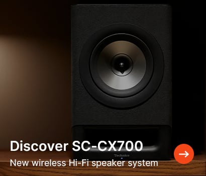 A sleek black speaker with a central cone on a wooden surface. Text reads "Discover SC-CX700: New wireless Hi-Fi speaker system," with an arrow icon.
