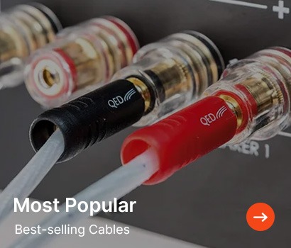 Close-up of audio cables connected to a speaker, with one black and one red, labeled "QED." Text reads "Most Popular Best-selling Cables" with an orange arrow.