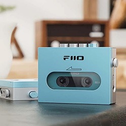 Retro-styled blue cassette player on a table, displaying a cassette tape inside through a clear window. Modern and nostalgic vibe.