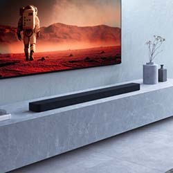 A sleek modern living room with a large TV displaying an astronaut on a red, Martian landscape. Minimalist décor and a black soundbar on a marble shelf.
