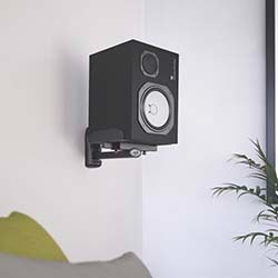 A sleek black electronic device with a colourful digital display and a control knob sits on a textured light pink surface.