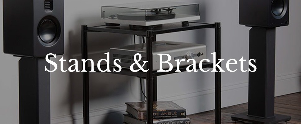A stylish living room setup with speakers on stands, a wall-mounted TV, a globe, and a turntable with audio equipment on a metal shelf. Text reads "Stands & Brackets."