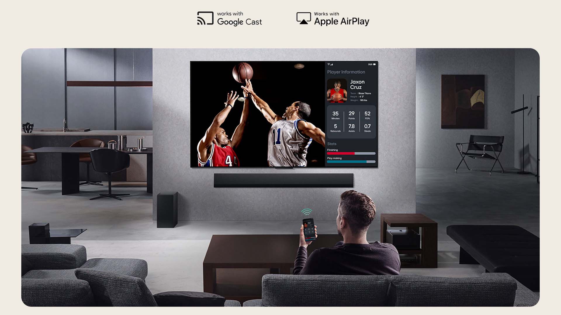 A man sits on a couch in a modern living room using a remote. He's watching a basketball game on a large TV displaying player stats, conveying a relaxed atmosphere.