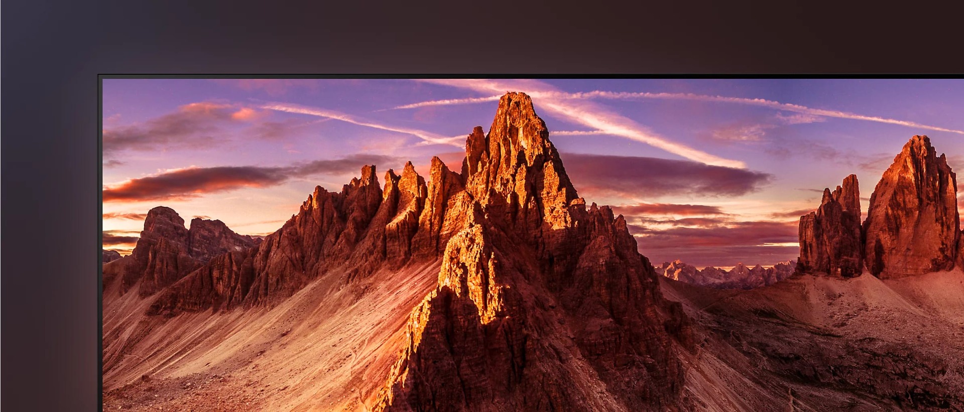 Detail of top left corner of TV showing screenshot of jagged mountains at sunrise.
