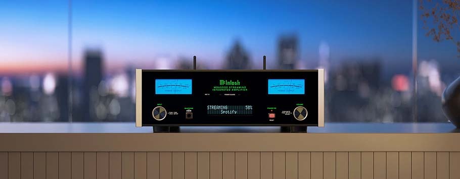 A sleek audio amplifier with glowing blue meters and digital display sits on a ledge, with a blurred cityscape at twilight in the background, creating a modern, serene ambiance.