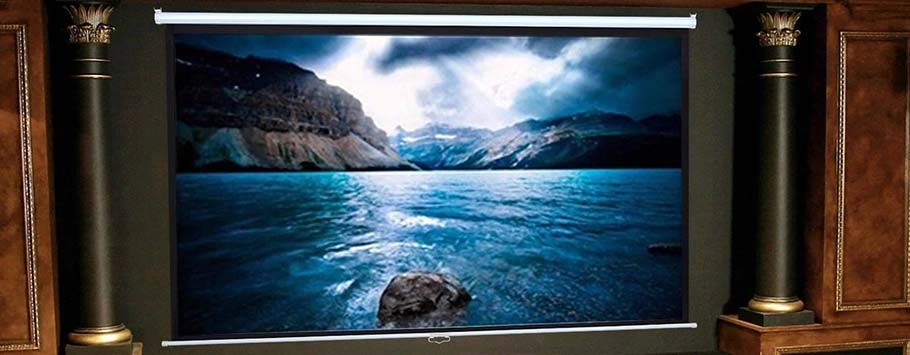 A large screen displaying a dramatic mountain and lake scene with stormy skies, set in a luxurious home theatre with dark columns and wooden panels.