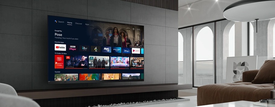 Sleek living room with a large flat-screen TV displaying streaming apps and shows. Modern sofa and arched windows create a stylish, serene atmosphere.